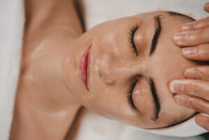 Shot of a beautiful young woman enjoying face massage at the beauty salon. Facial massage beauty treatment. Pinch and roll technique.