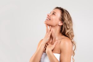 Woman holds her hand over her neck, thrilled with the results of Botox for neck bands